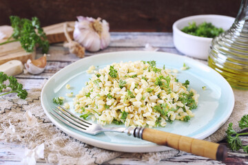 Vegetarian cuisine. Fried pearl barley with parsley, garlic and olive oil