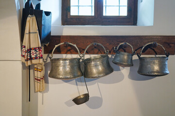 Old-fashioned wall in the kitchen with metal utensils