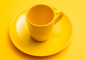 Empty mug on yellow saucer