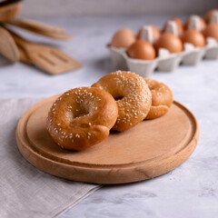 Homemade cakes on a wooden board. Bagels with sesame seeds. Homemade food concept.