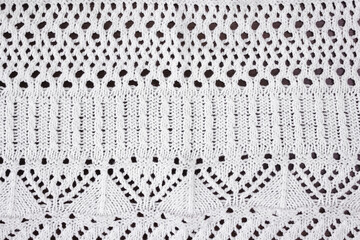 White textured background of openwork knitted fabric - obrazy, fototapety, plakaty