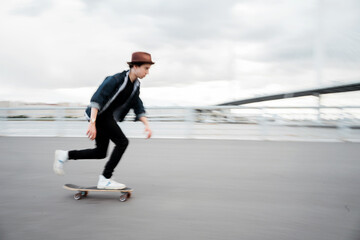 Melinial hipster man skateboarding walking in the city alone, blurry photo in motion. © muse studio
