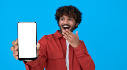 Happy excited surprised young indian man holding cellphone showing big white blank empty mockup...