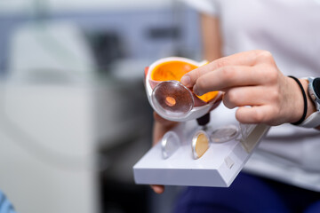 Ophthalmologist or surgeon holds an eye, eyeball prosthesis in hands . Concept photo for ocular...