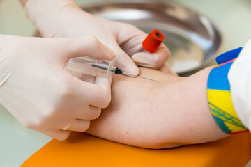 Laboratory worker doctor takes a blood sample for analysis. Procedure of taking blood in clinic. Close-up