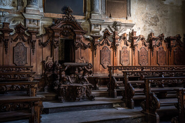 Beautiful wooden decoration, benches and a pupit in the abandoned church Santo Siro e Libera in...