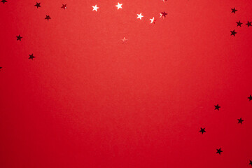 Red stars shapes at the top on red background. Christmas winter holiday concept flat lay top view...