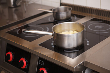 Pot with boiled potatoes on a stove