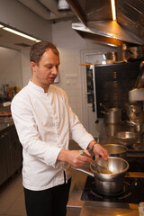 Vertical shot of a professional chef preparing sauce at the kitchen