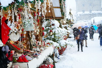 Traditional Christmas market under heavy snowfall. Aosta, Italy -December 2021 - obrazy, fototapety, plakaty