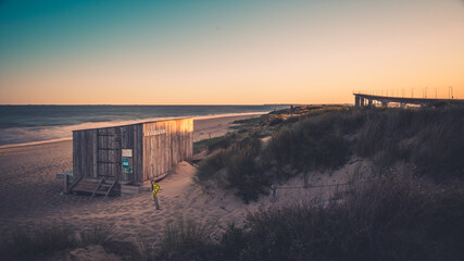 kitesurfing hut at the end of the season at sunrise. bridge of ile de ré in the background.