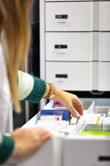 Pharmacist placing medicines in drawers