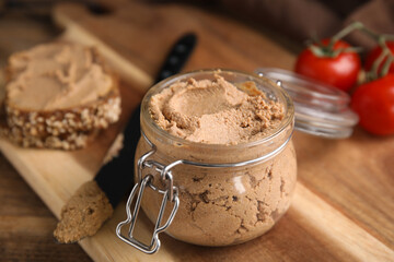 Delicious meat pate with knife on wooden table, closeup