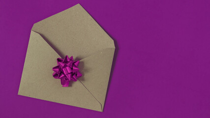 Open blank kraft paper envelope on purple background.