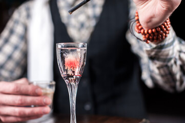 Experienced bartending adds ingredients to a cocktail