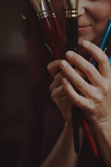 Young beautiful girl, the artist holds paintbrushes in her hands.	
