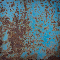 The texture of the old painted metal door. Brown rusty stains on a blue background.