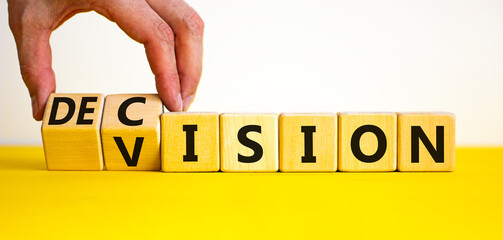 Vision and decision symbol. Businessman turns wooden cubes and changes the word decision to vision....