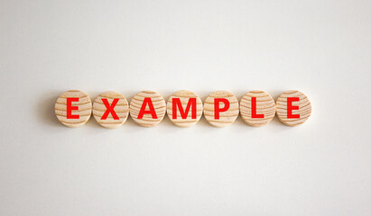Example symbol. The concept word Example on wooden circles. Beautiful white background, copy space. Business and example concept. - obrazy, fototapety, plakaty