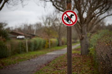 Sign in a park that dogs are not allowed to do their business here, no dog poo