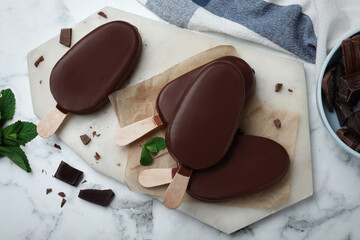 Delicious glazed ice cream bars with mint and chocolate on white marble table, flat lay - obrazy, fototapety, plakaty