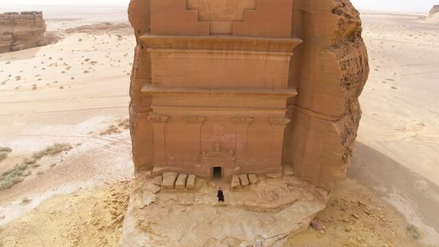 Aerial Descending Down To A Woman As She Enters The Historic Tomb Of Mada'In Salih - Hegra, Saudi Arabia