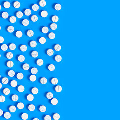 Background from white pills on a blue surface. Production of drugs. Medical theme. 3d rendering. 