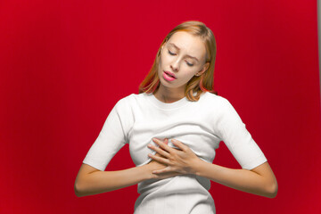 Sick young girl holding chest with painful face. Cardiac problems, heart health, panic attack and...