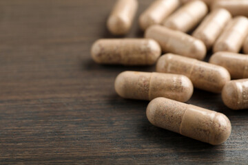 Gelatin capsules on wooden table, closeup. Space for text