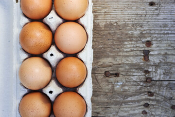 farm brown eggs in a box on the old wooden table with top view