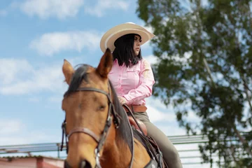 Foto op Canvas Close up of a beautiful girl riding a horse in a ranch © ERNESTO