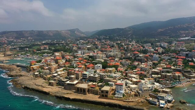 Aerial Panning Beautiful Shot Of Buildings In City Against Sky, Drone Flying Over Sea - Batroun, Lebanon