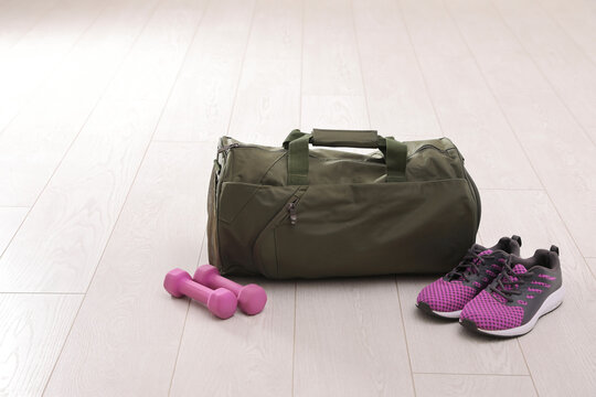 Sports bag and gym equipment on white floor