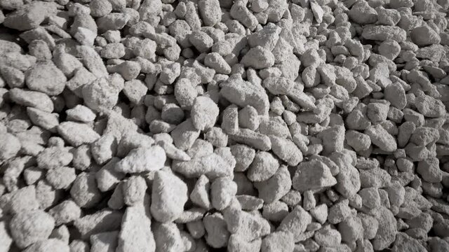 Sorted limestone rock in embankment. Open pit mining quarry. Extractive industry, grey background. Construction site, geology concept.