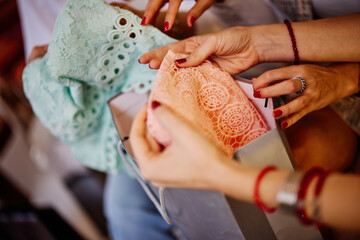 Girls' hands holding clothes they bought on retail.
