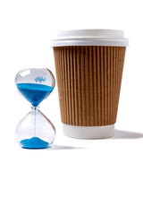 Cardboard cup with plastic white lid for hot drink on isolated white background and blue sand clock. Mug for coffee or hot tea. Time for beverage concept.