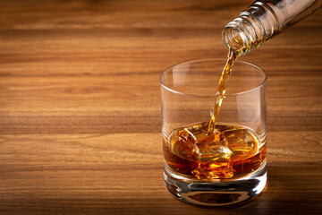 Pouring whiskey into the glass.