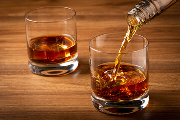 Pouring whiskey into the glass.