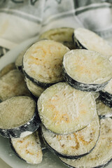 eggplant aubergine slices covered in flour, breaded for frying 