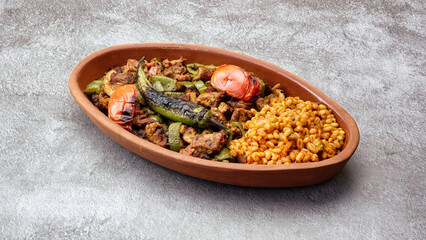 Close up of Turkish chicken Kebab called Mudurnu Kebab, garnished with vegetables, bulgur pilaf served on ceramic dish - Turkish, Food Kebab- 