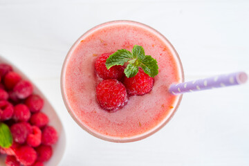 Raspberry smoothie red colorful fruit juice milkshake blend beverage healthy high protein the taste yummy In glass drink episode morning on white wood background from top view.