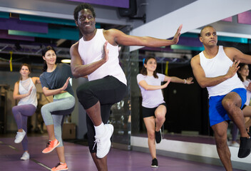 Portrait of excited man dancing during group class in dance center