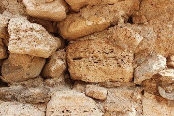 The wall is made of porous stone. Background, surface, texture