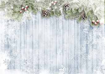 Сhristmas card. Wooden background with snow firtree, cones and red berry. Season's greetings