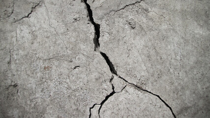 Vertical concrete crack on a rough texture. Retro effect of aging and destruction.