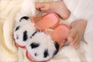 Close up bare foot in the morning at home, relaxing. Funny fluffy panda slippers. Comfort aesthetics style