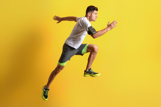 Sporty male runner on color background