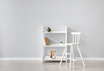 White chair and bookcase near light wall