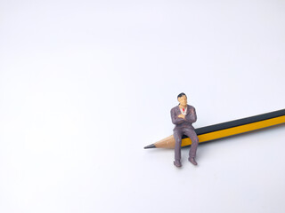 Miniature people and pencil on a white background. Businessman concept idea.