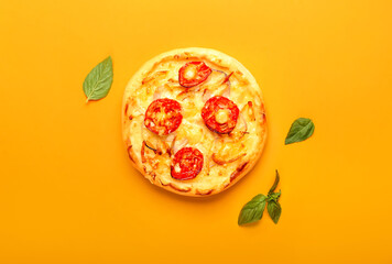 Delicious mini pizza and basil on orange background